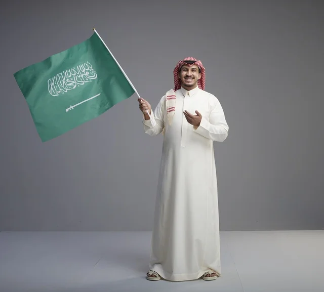 رجل سعودي يلوح بعلم المملكة العربية السعودية