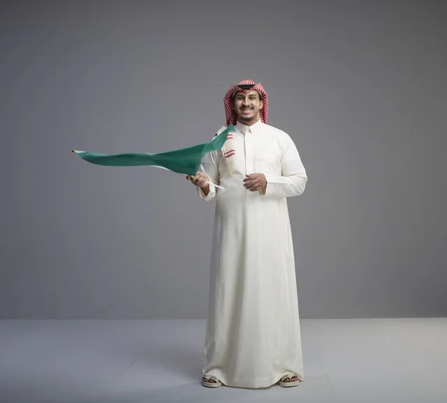 Saudi Man Waving Saudi Arabia Flag in Studio