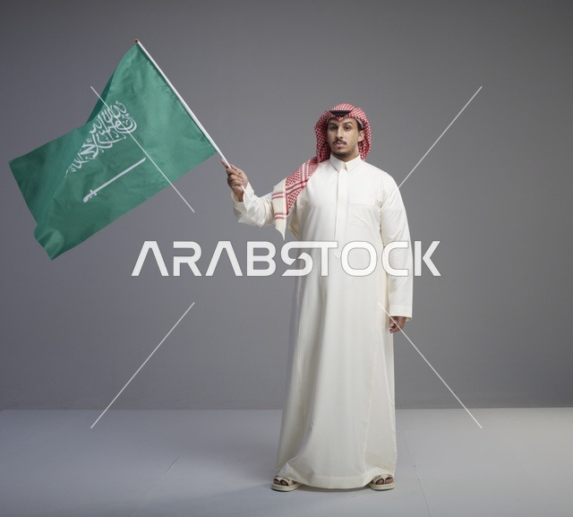 رجل سعودي يحمل علم المملكة العربية السعودية