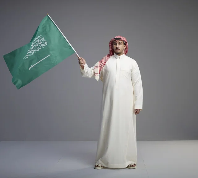 Saudi Man Holding Saudi Arabia Flag in Studio