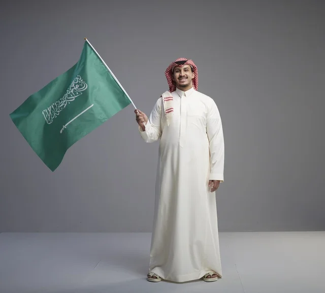Saudi Man Holding National Flag in Studio Portrait