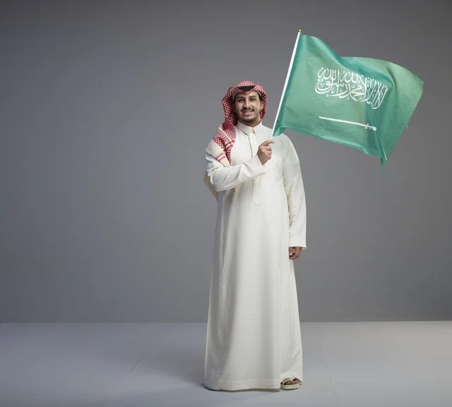 رجل سعودي يرفع العلم السعودي في استوديو