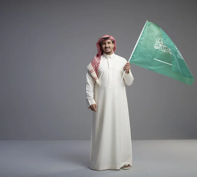 Saudi Man Holding National Flag in Studio