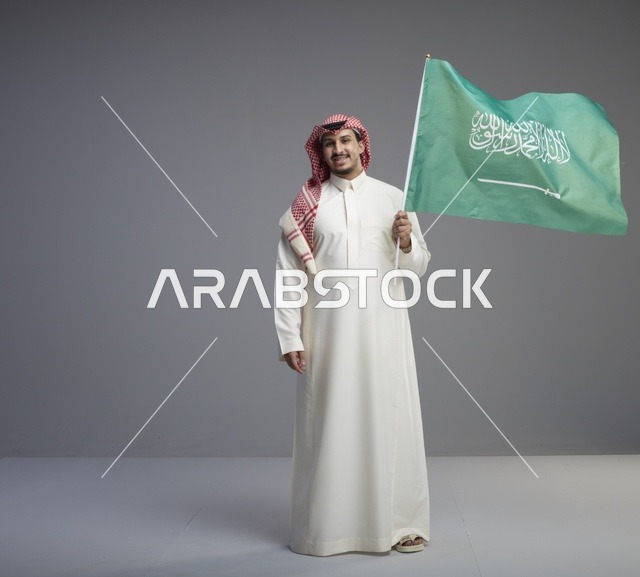 رجل سعودي يحمل علم المملكة العربية السعودية