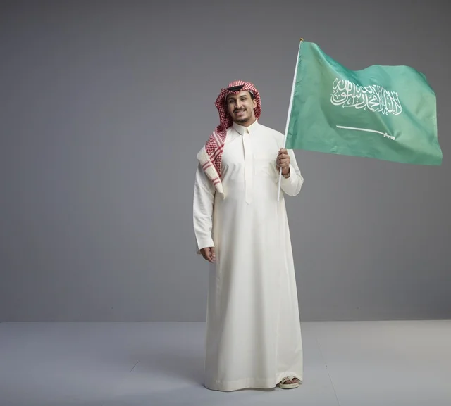 Saudi Man Holding Saudi Arabia Flag in Studio