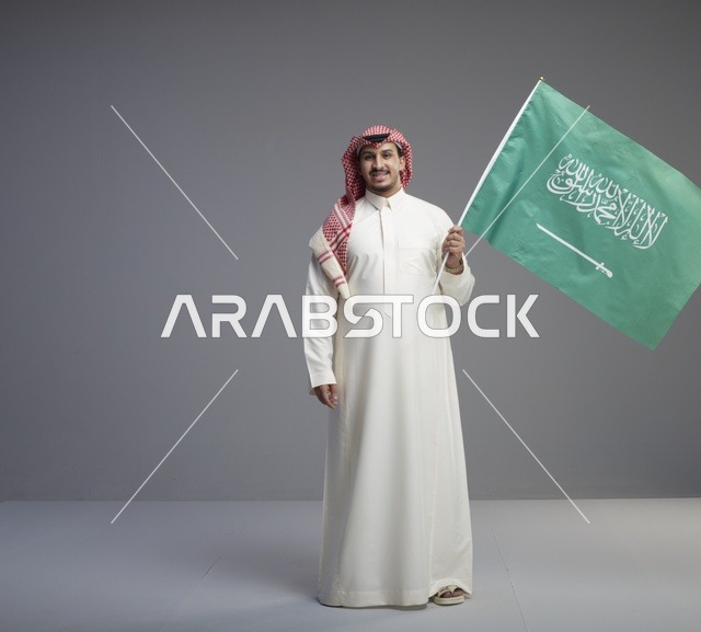 رجل سعودي يحمل علم المملكة العربية السعودية