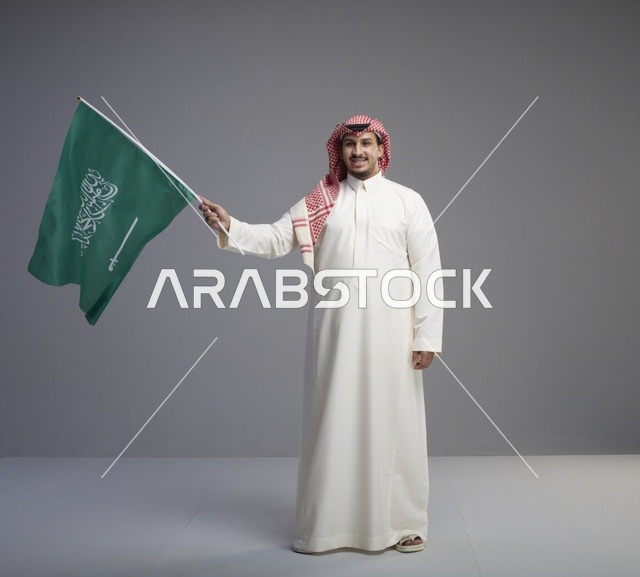 رجل سعودي يلوح بعلم المملكة العربية السعودية في استوديو