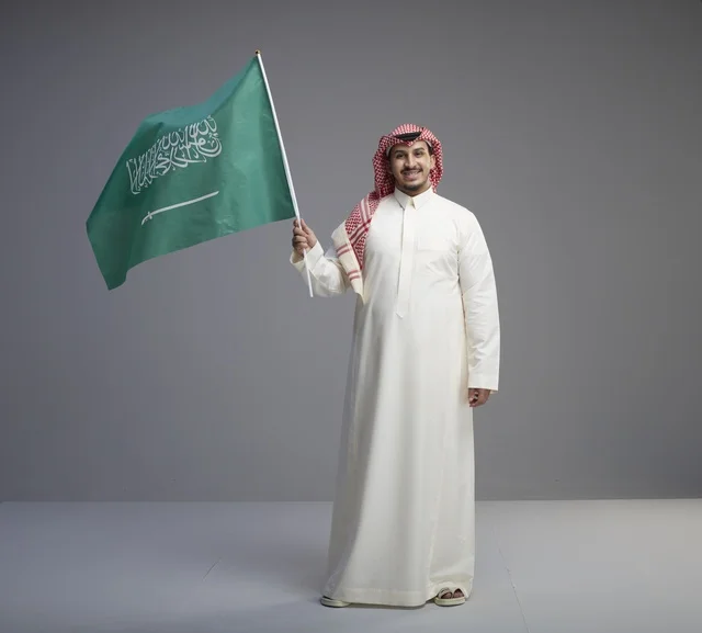 رجل سعودي يحمل العلم السعودي في الاستوديو