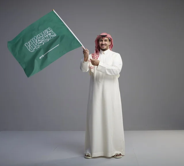 Saudi Man Waving Saudi Arabia National Flag in Studio