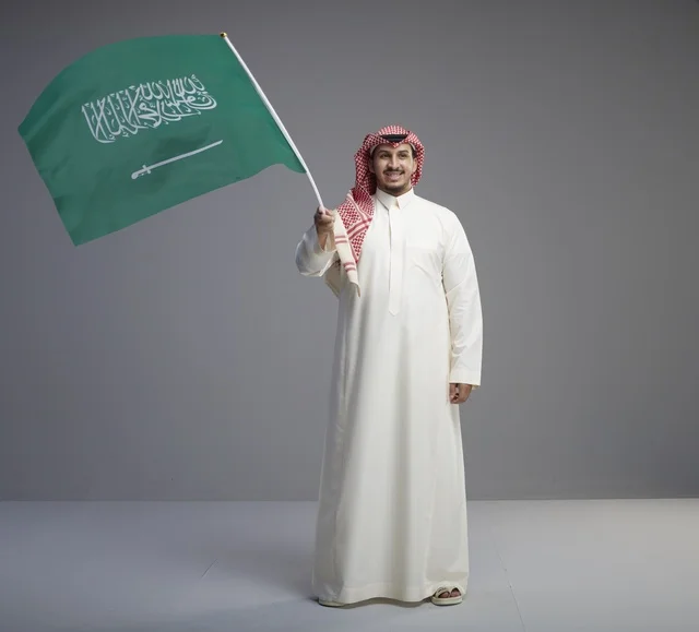 رجل سعودي يحمل العلم السعودي في الاستوديو