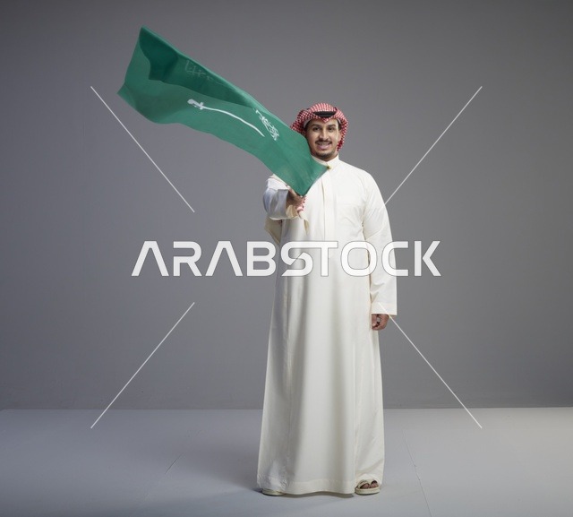 رجل سعودي يلوح بعلم السعودية في الاستوديو