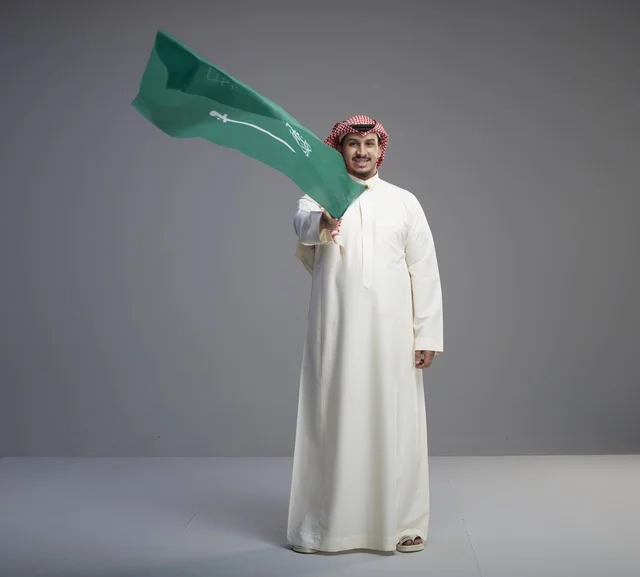 رجل سعودي يلوح بعلم السعودية في الاستوديو