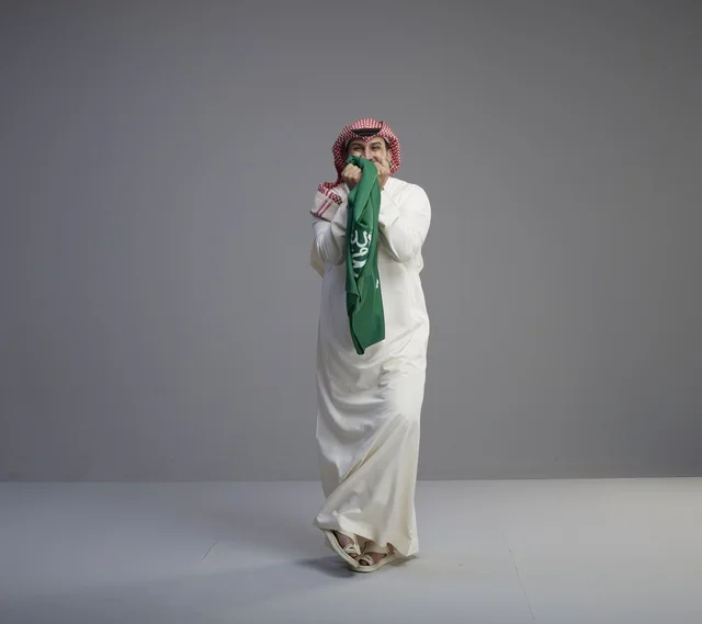 رجل سعودي يحمل العلم السعودي في الاستوديو