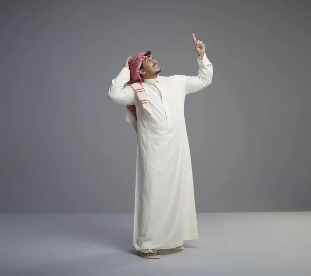 Saudi Man in Traditional Thobe Pointing Upward