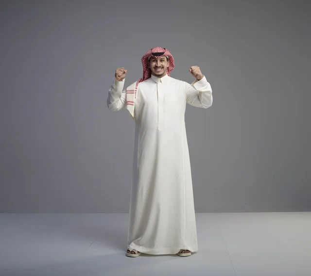 رجل سعودي بالزي التقليدي يحتفل بالنجاح
