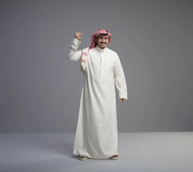 رجل سعودي يحتفل بالنجاح بالزي التقليدي