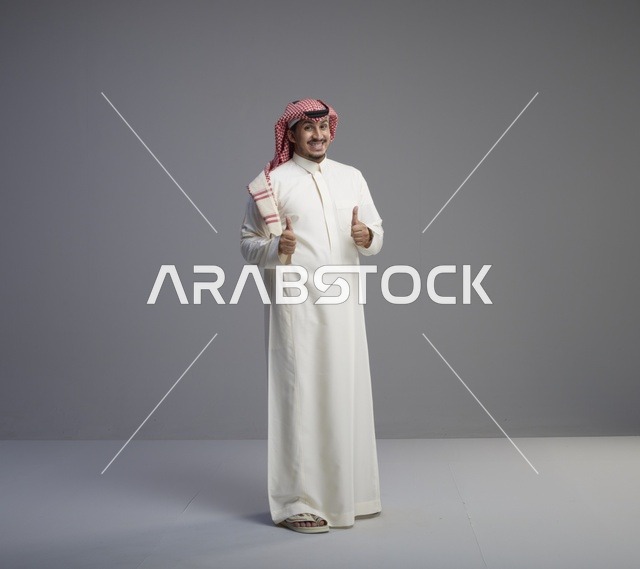 رجل سعودي بالزي التقليدي يرفع إبهامه للأعلى