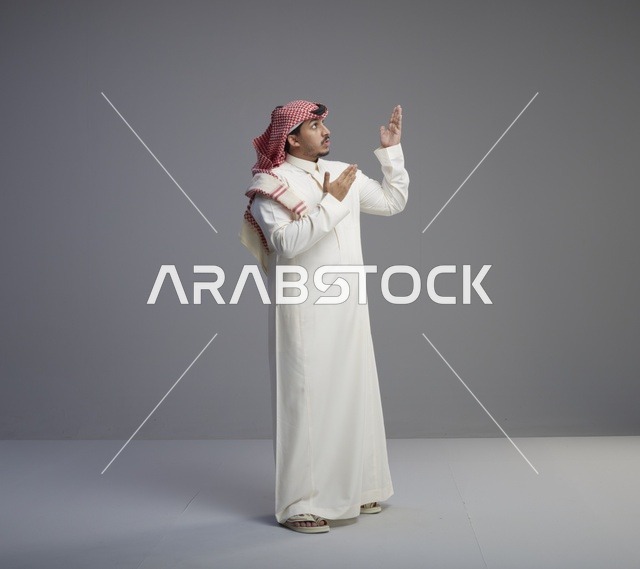 رجل سعودي بالزي التقليدي في وضعية الدعاء