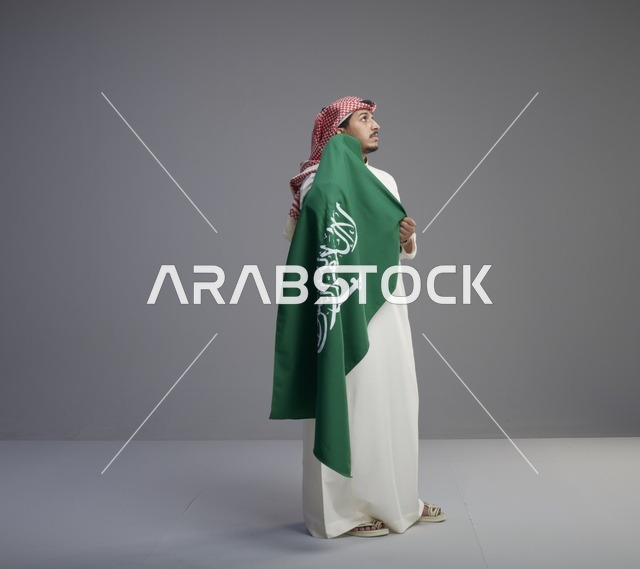 رجل سعودي يحمل العلم الوطني في الاستوديو