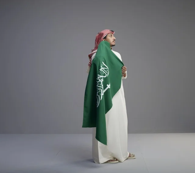 رجل سعودي يحمل العلم الوطني في الاستوديو