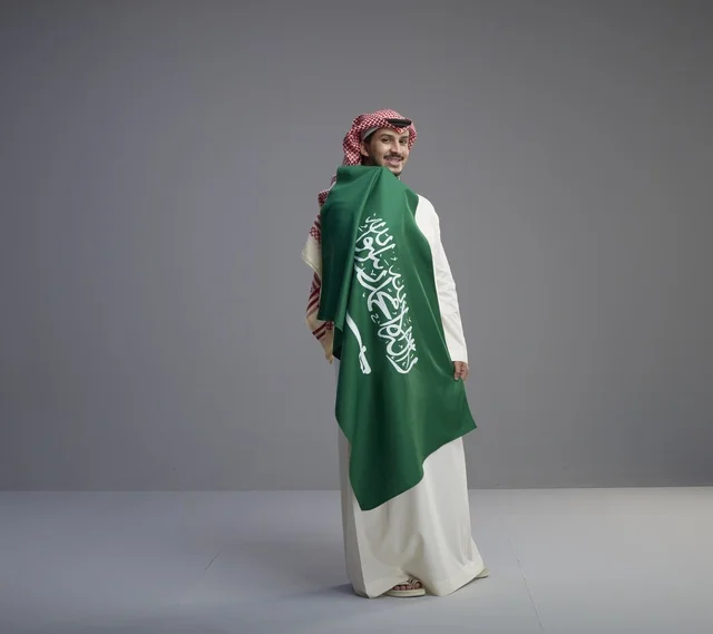 Saudi Man Carrying National Flag in Studio Background