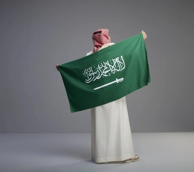 Saudi Man Holding Saudi Arabia Flag from Behind