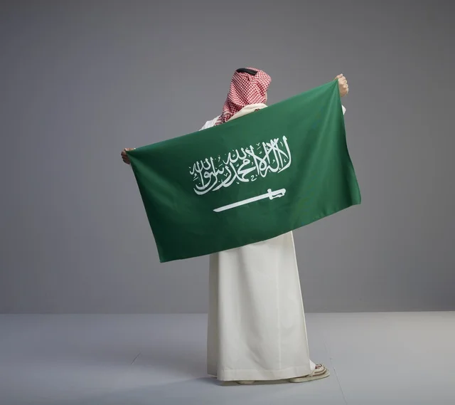 Saudi Man Holding National Flag from Behind