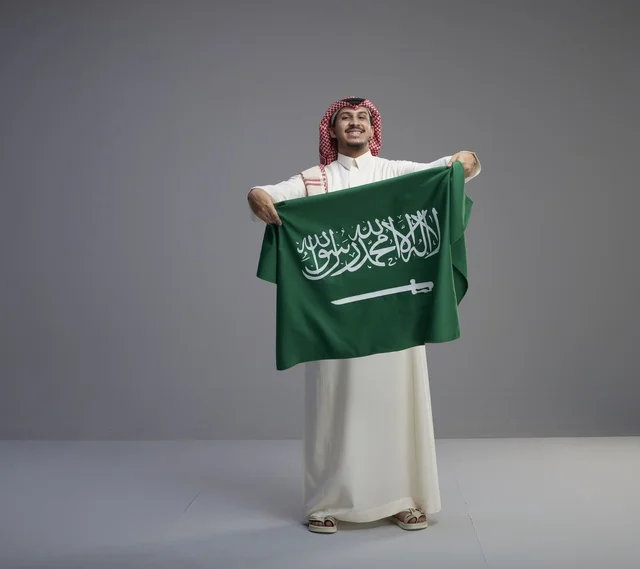 رجل سعودي يحمل العلم الوطني السعودي في الاستوديو