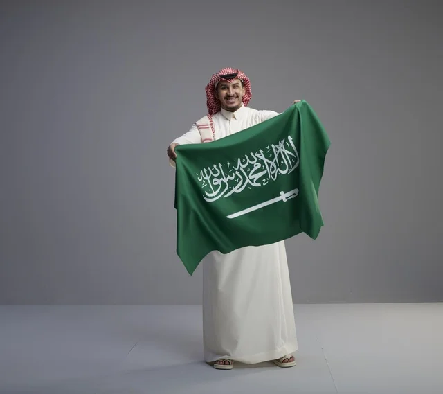 رجل سعودي يحمل العلم الوطني في الاستوديو