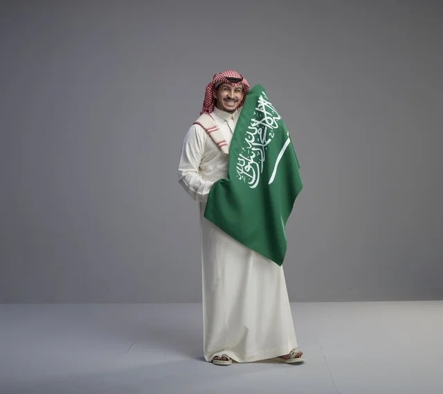 Saudi Man Holding National Flag on Grey Background