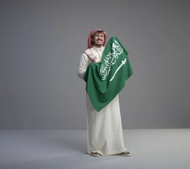 Saudi Man Holding National Flag in Studio Portrait