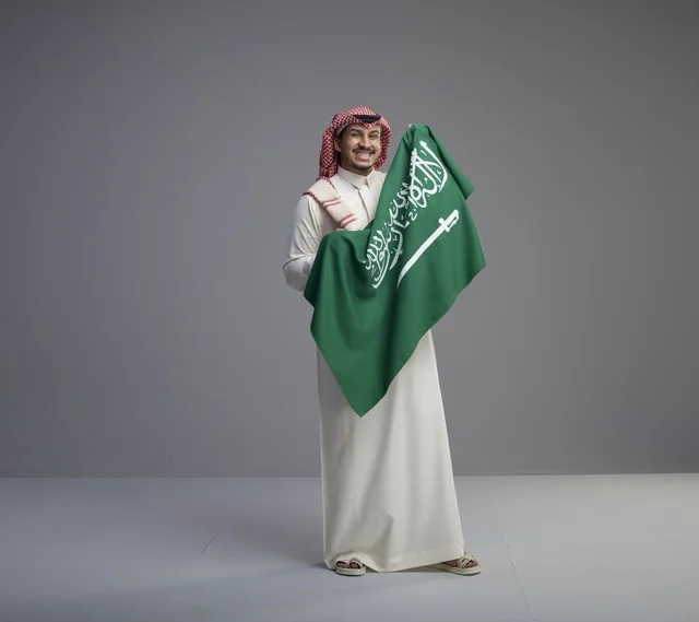 رجل سعودي يحمل العلم الوطني في الاستوديو