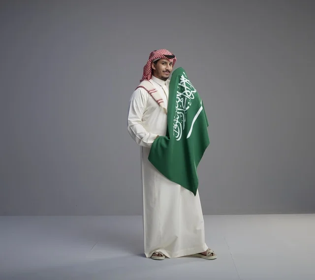 Saudi Man Holding National Flag in Studio