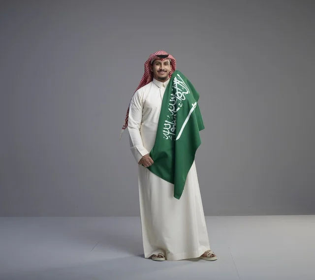 Saudi Man Holding National Flag in Studio