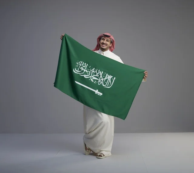 رجل سعودي يحمل العلم الوطني في الاستوديو