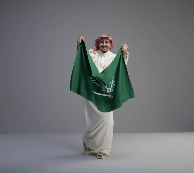 رجل سعودي يحمل العلم الوطني للمملكة العربية السعودية
