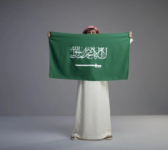 رجل سعودي يحمل العلم الوطني في الاستوديو