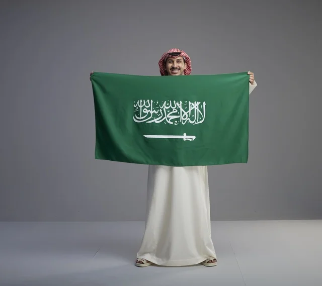 Saudi Man Holding Saudi National Flag in Studio