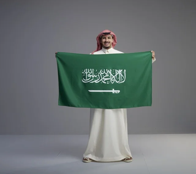 Saudi Man Holding Saudi National Flag in Studio