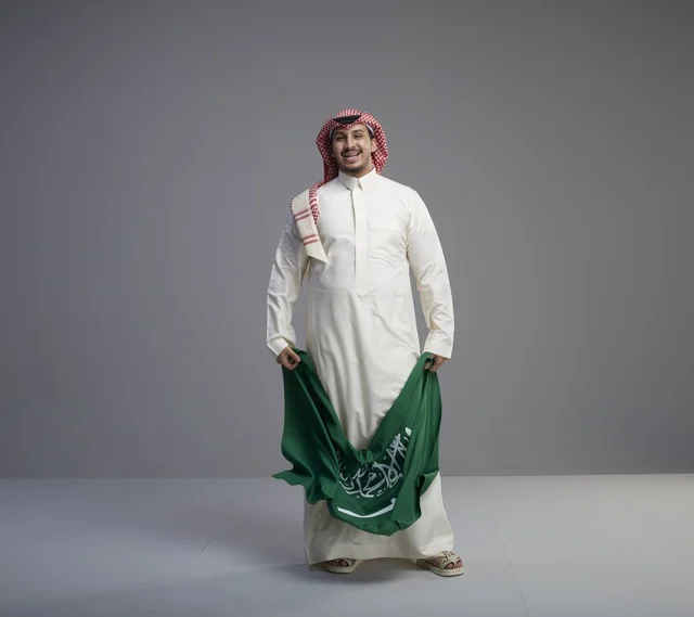 رجل سعودي يحمل العلم الوطني السعودي في الاستوديو