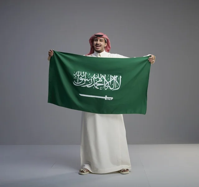 رجل سعودي يحمل العلم الوطني في الاستوديو