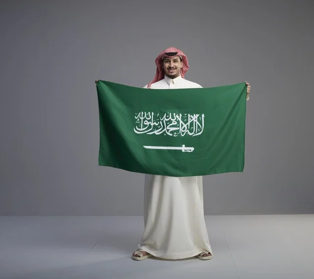 رجل سعودي يحمل العلم الوطني في الاستوديو