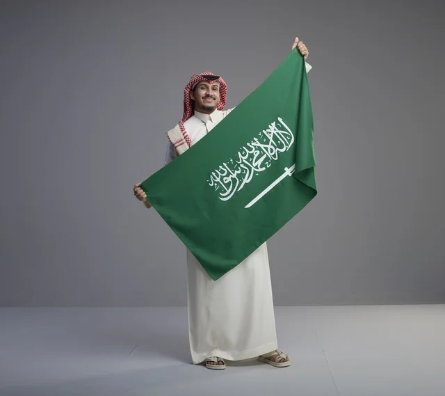 Saudi Man Holding Saudi Arabia National Flag in Studio