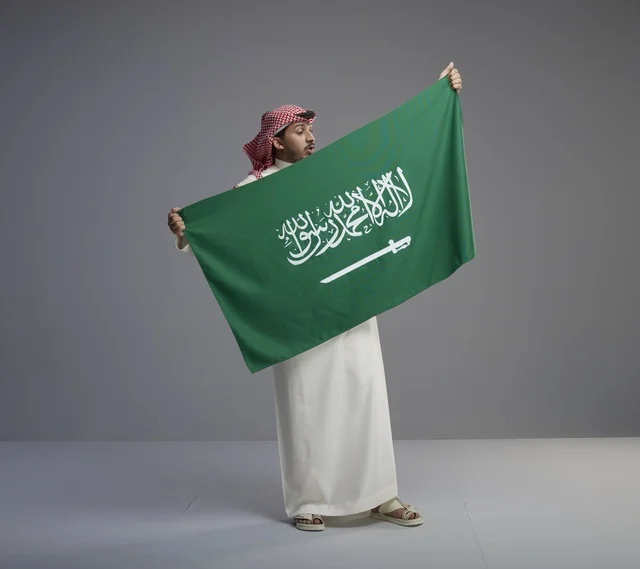 رجل سعودي يحمل العلم الوطني السعودي في الاستوديو