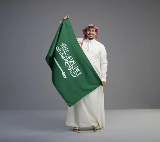 رجل سعودي يحمل العلم الوطني في الاستوديو