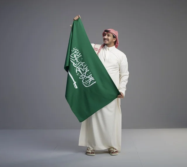 رجل سعودي يحمل العلم الوطني السعودي