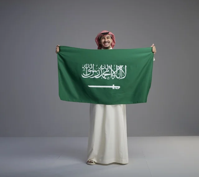 Saudi Man Holding Saudi National Flag in Studio