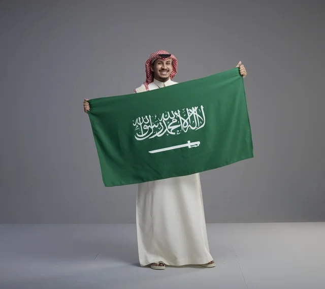 Saudi Man Holding National Flag of Saudi Arabia in Studio