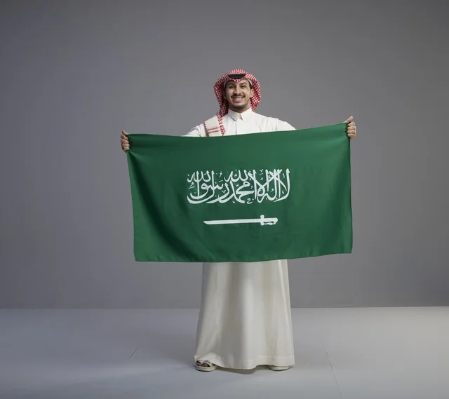 رجل سعودي يحمل العلم الوطني السعودي في الاستوديو