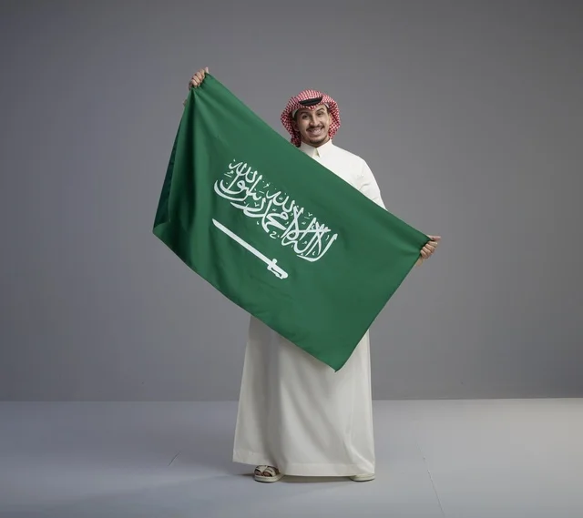 رجل سعودي يحمل العلم الوطني السعودي في الاستوديو